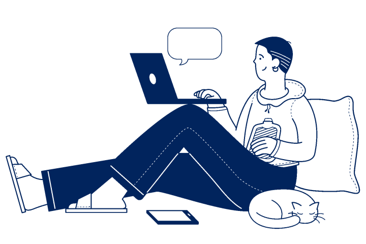 smiling young person with a laptop perched on their knees and a cat curled up asleep next to them