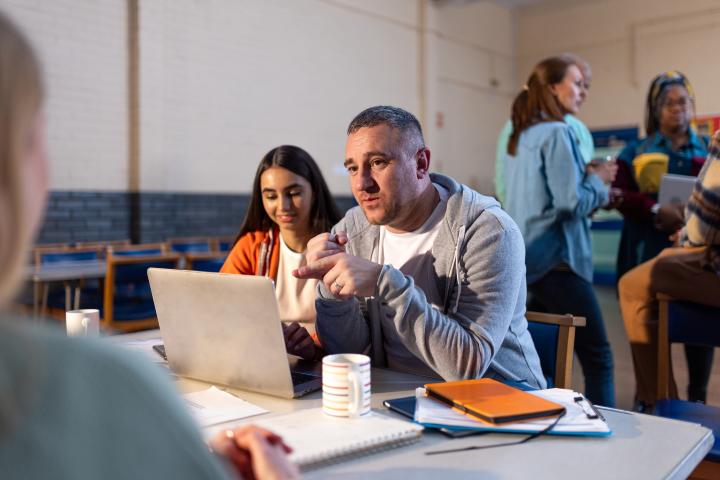 over-the-shoulder shot of a staff member entering details into a laptop in a community centre event