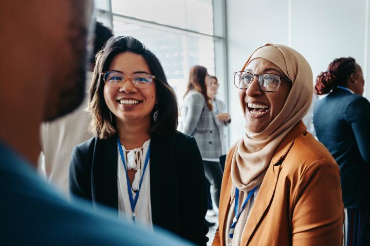 female colleagues interacting at a workshop, sharing happy smiles and engaging in lively conversations