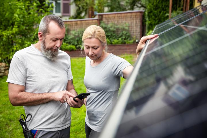 an installer explains a newly installed solar panel system to customer