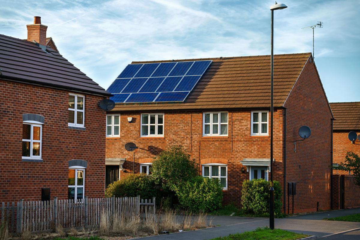 solar photovoltaic panels mounted on a red brick tiled house roof