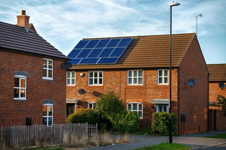 solar photovoltaic panels mounted on a red brick tiled house roof
