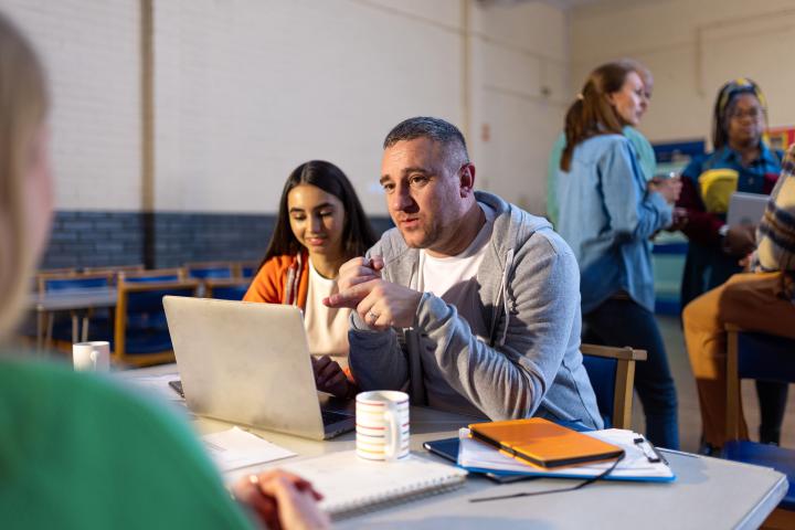 over-the-shoulder shot of a staff member entering details into a laptop in a community centre event