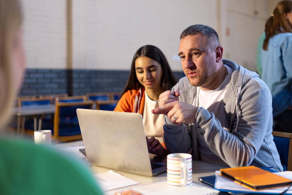 over-the-shoulder shot of a staff member entering details into a laptop in a community centre event