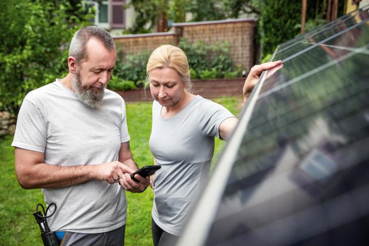 an installer explains a newly installed solar panel system to customer