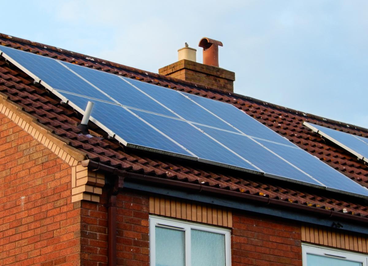 solar panels mounted on a house with a red tile roof